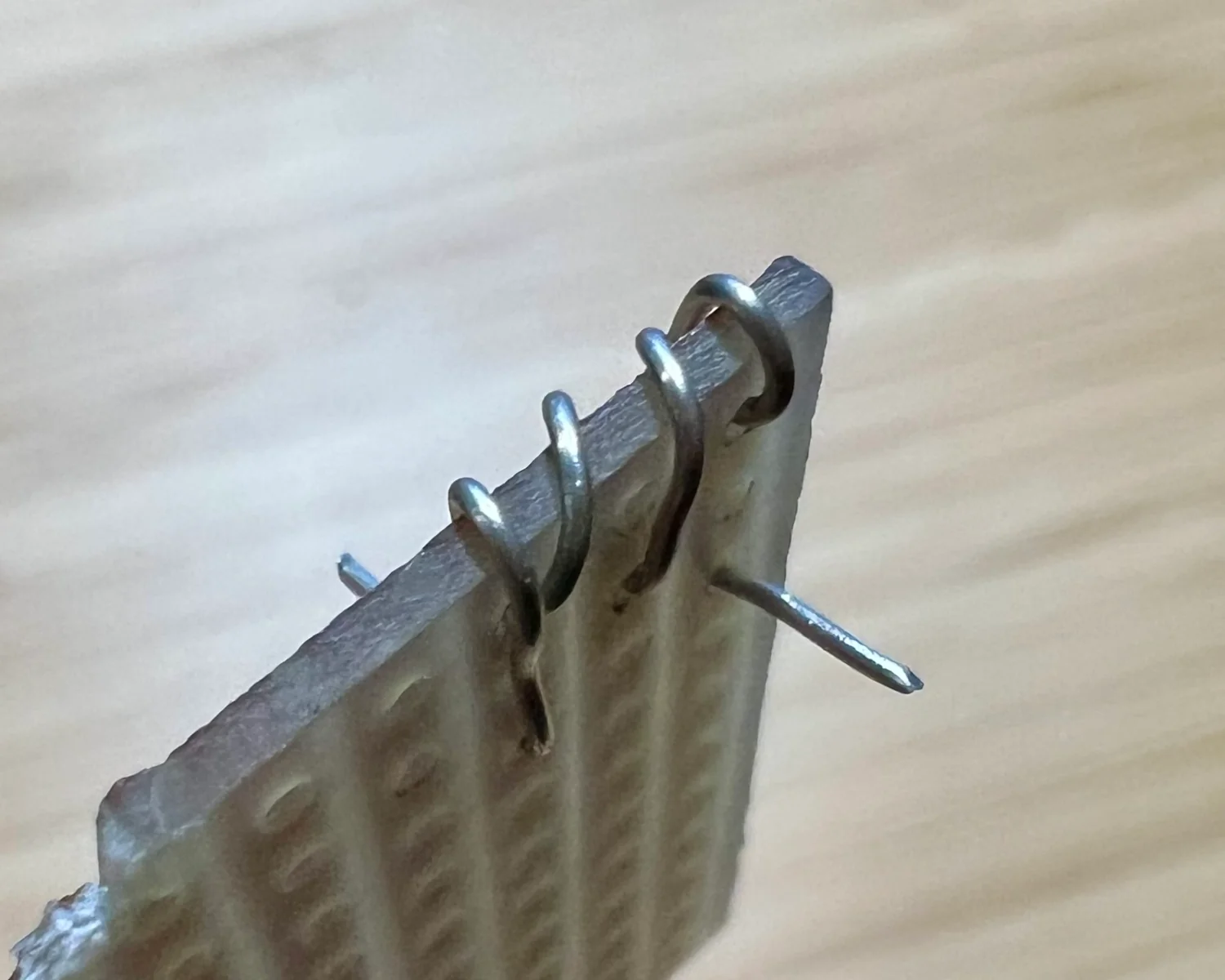 Oblique photo of wire laced over the edge of a PCB.