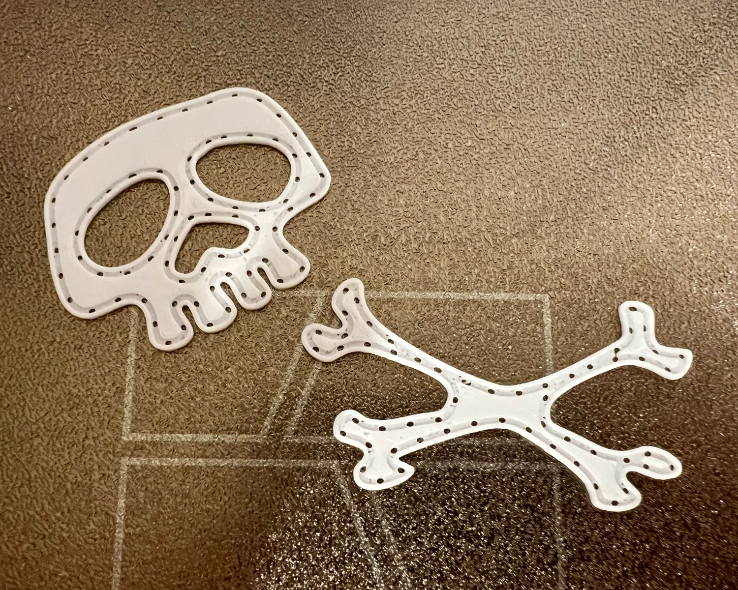 The two parts of the badge, printed, on a 3D printer build plate.