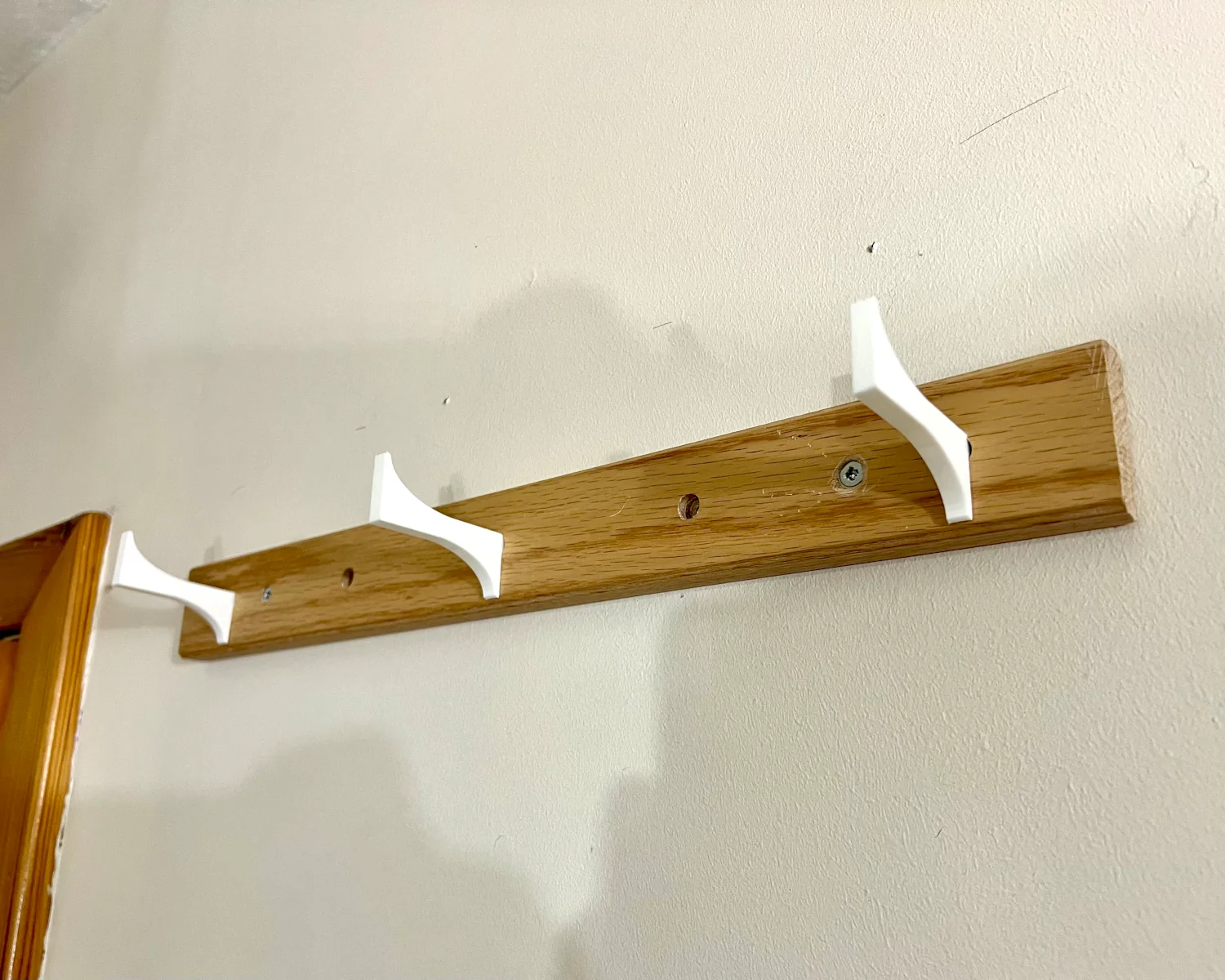 3 3D printed helmet hooks fitted to an IKEA HÖVOLM.