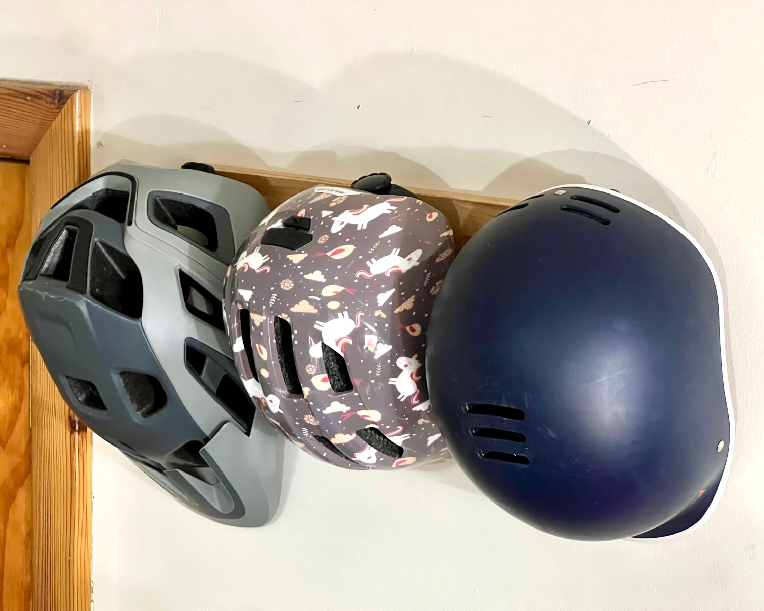 3 helmets hanging from an IKEA HÖVOLM.