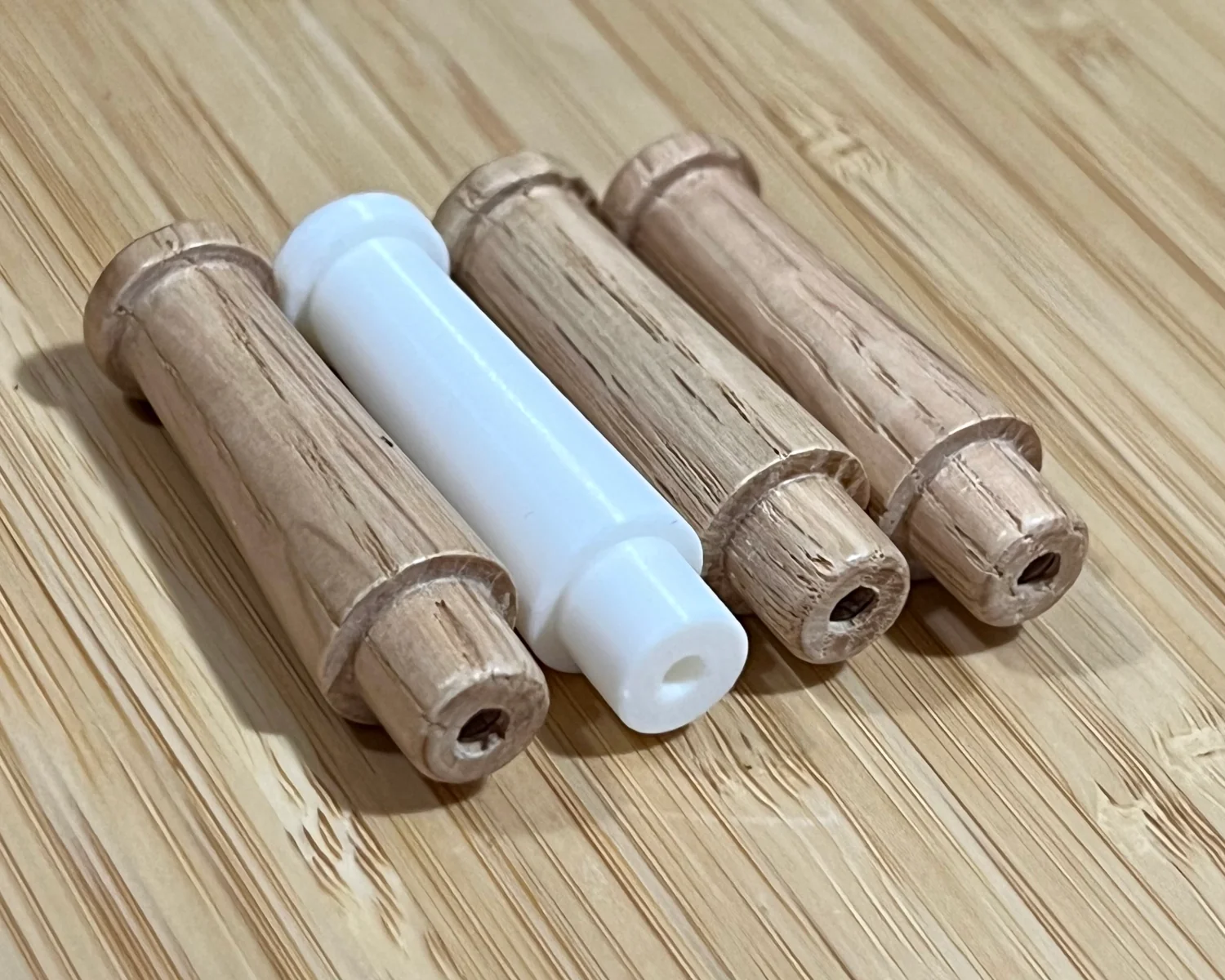 A 3D printed peg between identical wooden ones.