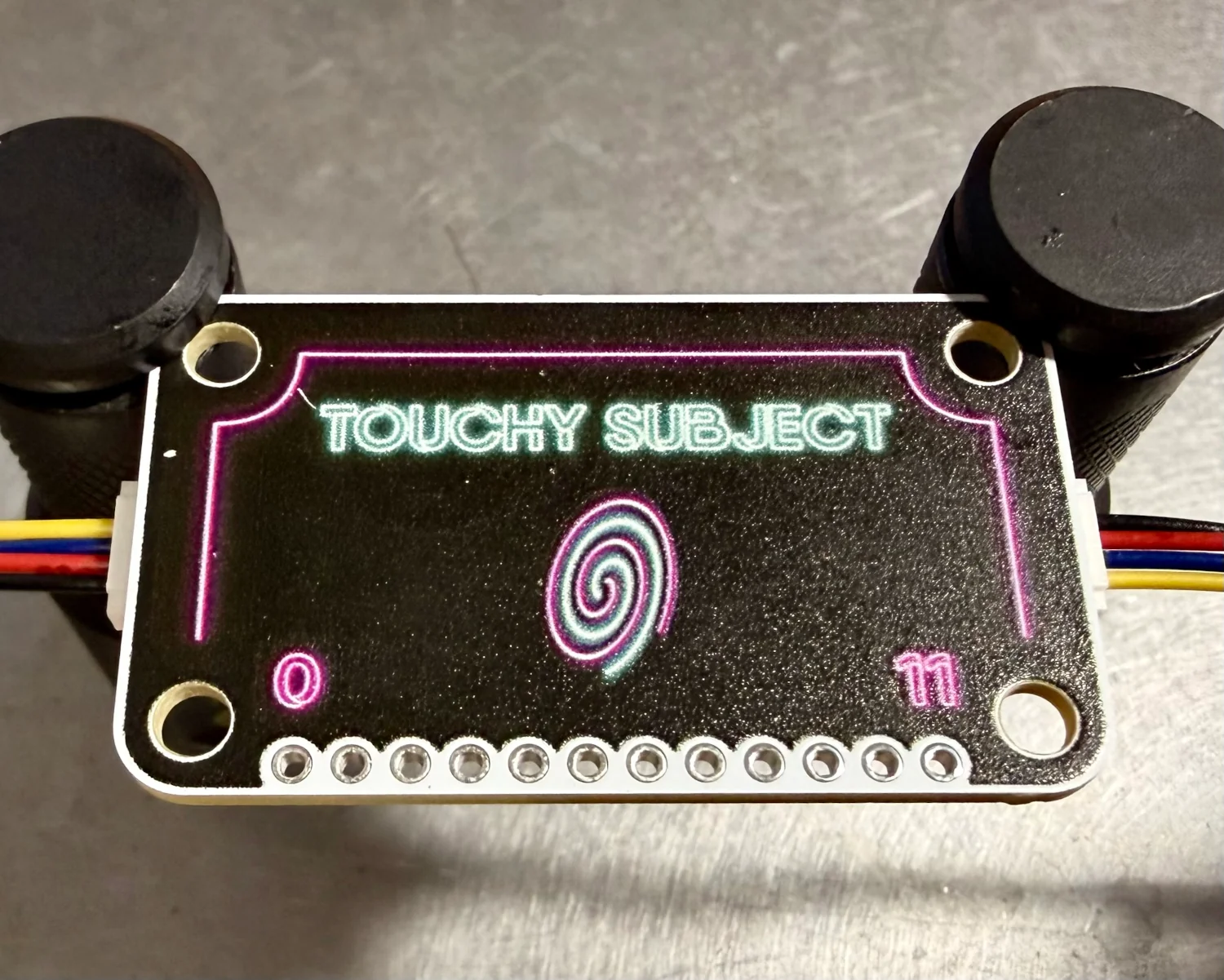 A Touchy Subject mounted in a test jig with the artwork visible.